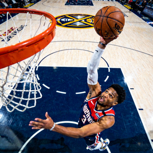 Pemain basket melakukan tembakan tiga angka ke ring